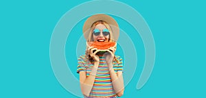 Summer portrait of happy smiling young woman with fresh juicy slice of watermelon wearing straw hat on blue background