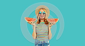 Summer portrait of happy smiling young woman with fresh juicy slice of watermelon wearing straw hat on blue background