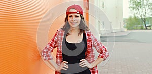 Summer portrait of happy smiling young woman posing in red baseball cap, casual clothes