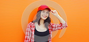Summer portrait of happy smiling young woman posing in red baseball cap, casual clothes