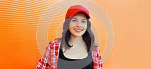 Summer portrait of happy smiling young woman posing in red baseball cap, casual clothes