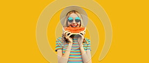 Summer portrait of happy young woman eating fresh slice of watermelon on yellow studio background