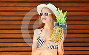 Summer portrait smiling woman with funny pineapple in sunglasses