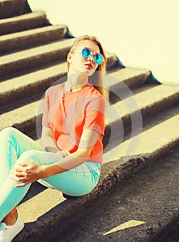 Summer portrait of stylish blonde young woman wearing sunglasses in the city