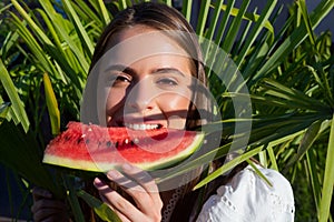 Summer portrait woman is holding a slice of watermelon. Tropical vacation travel concept. Positive charming youth girl