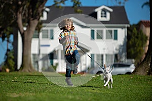 Summer portrait of a young caucasian boy running small dog.