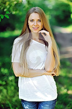 Summer portrait of young smiling blonde woman outdoor