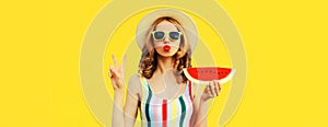Summer portrait of young woman blowing her lips with red lipstick with fresh slice of watermelon on yellow background