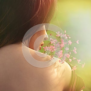 Summer portrait of young  woman  with flower  back shot closeup outdoors