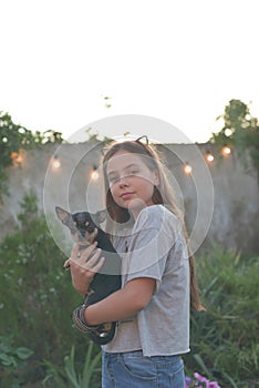 Summer portrait of a young woman on nature with a dog breed Chihuahua