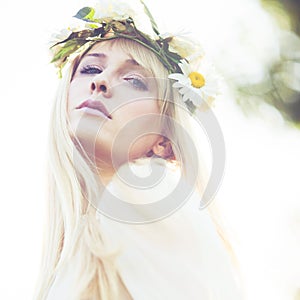 Summer portrait of  young woman  with wreath of flowers in hair outdoor shot