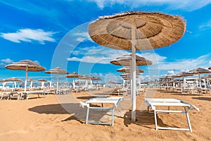 Summer recreation. Straw sun umbrellas on beach.