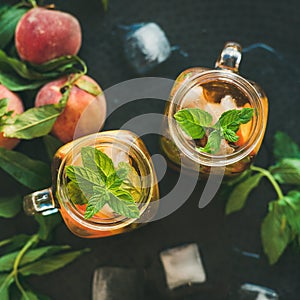 Summer refreshing cold peach ice tea in jars, square crop