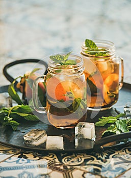 Summer refreshing cold peach ice tea with mint, copy space