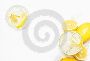 Summer refreshing drink, cold water with ice and lemon, white ba