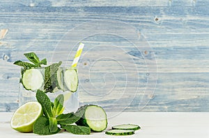 Summer refreshing drink with cucumber, mint, ice and lime on old wood board. Holiday beach fresh background.