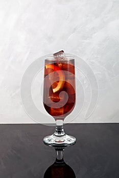 Summer refreshing drink. Iced cocktail with lemon. Cold drink on grey background, vertical orientation, copy space photo