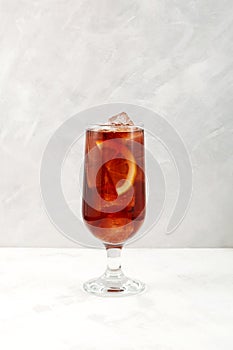 Summer refreshing drink. Iced cocktail red wine based with lemon. Cold drink on grey background photo