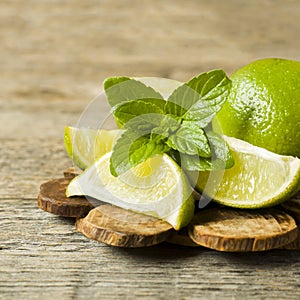 Summer refreshing drinks lemonade or cocktail Mojito with lime fresh mint blueberry ice. Wooden background