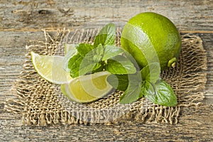 Summer refreshing drinks lemonade or cocktail Mojito with lime fresh mint blueberry ice. Wooden background
