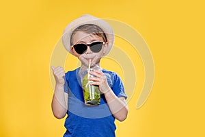 Summer refreshment. Cold beverage. Little boy with plastic cup of fresh lemonade