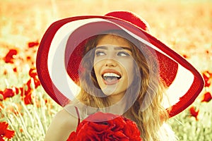 Summer rest. Fashionable woman posing. girl in field of poppy seed in retro hat