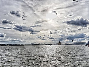 Summer, river, city, sunset, grey sky with dark blue clouds and wildlife.