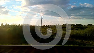 Summer rural flat landscape at sunset from the train window.