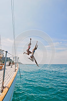 Summer, sailing and friends jumping off a yacht together into the ocean for freedom, fun or swimming. Travel, energy and