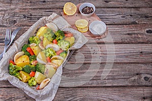 Summer salad with broccoli, carrots,white onion, garlic and potatoes sprinkled with spicy herbs and parsley close up on a plate