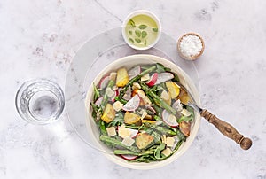 Summer salad with potatoes, green asparagus, arugula, and radishes. Seasonal diet food.