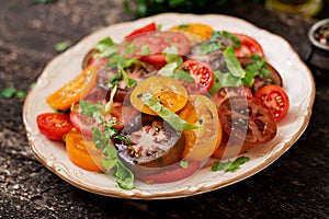 Summer salad of tomatoes of different colors with green herbs