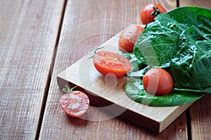 Summer salad with tomatoes in white plate on wood table