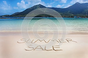 The Summer sale word written on the beach sand.