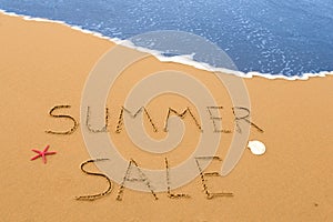 Summer sale written in the sand