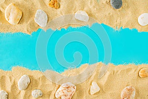 Summer sandy beach concept with rocks on blue background. Summer abstract tropic art with copy space