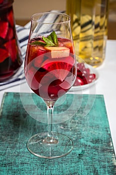 Summer sangria cocktail in wine glass , plate with dogwood berries