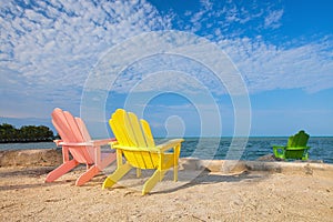 Summer scene with colorful lounge chairs on a tropical beach