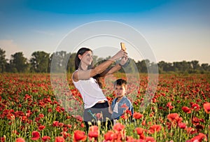 Summer scene of happy mother and son taking selfie