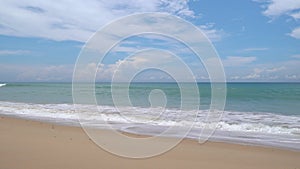Summer sea background.Blue sky white clouds over ocean waves break on sand beach.Waves crashing against an empty beach.Sea waves a