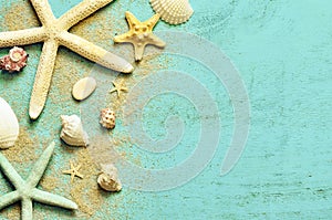 Summer sea background. Starfish, seashells and sand on a wooden blue background