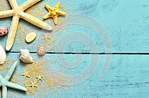 Summer sea background. Starfish, seashells and sand on a wooden blue background