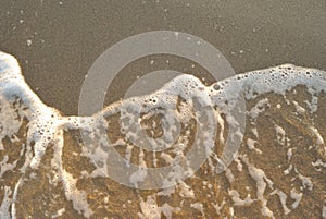 Summer sea, foam of undertow on a beach photo