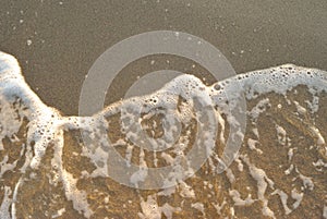 Summer sea, foam of undertow on a beach