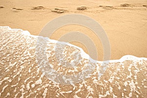 Summer sea, footprint and foam on a seashore