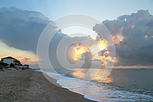 Summer seascape. Sunrise on the beach and cloudy sky