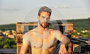 Summer season. Fitness model. Sexy pensive man relaxing outdoors. Muscular body. Muscular chest. Muscular bare torso