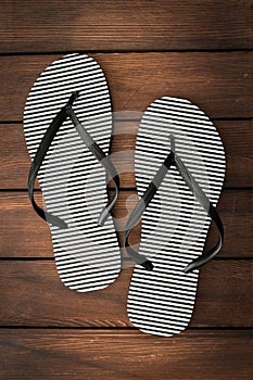 Summer shoes rubber flip flops isolated on brown wooden background