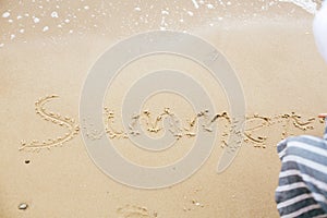 Summer sign on beach. Girl writing summer text on sandy beach at sea. Hello summer concept. Vacation, relax and travel