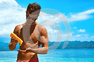 Summer Skincare. Man Applying Sunscreen Protection Body Lotion